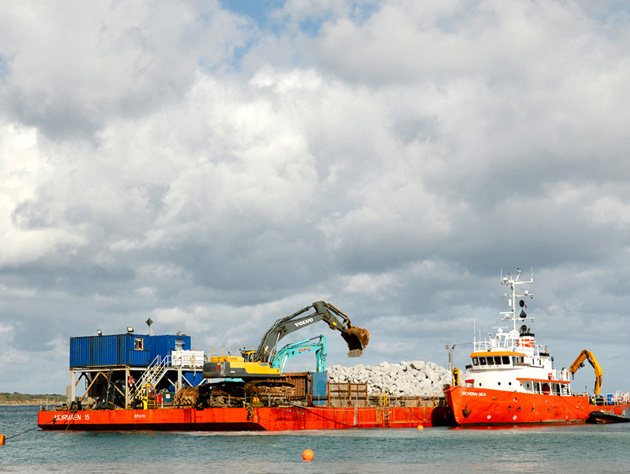 Barge Unlaoding Rock Armour At Sea